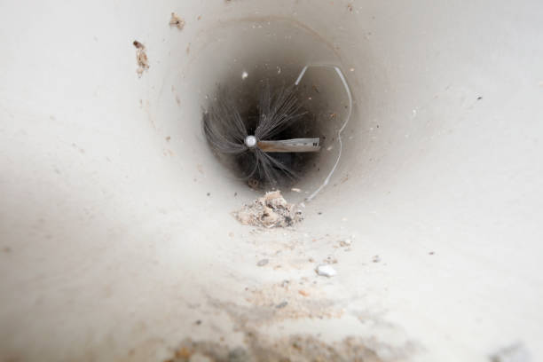 A duct cleaning brush running through a dirty air duct.